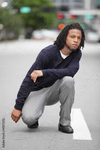 Man squatting in the street