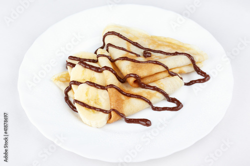 Thin pancakes with banana and chocolate