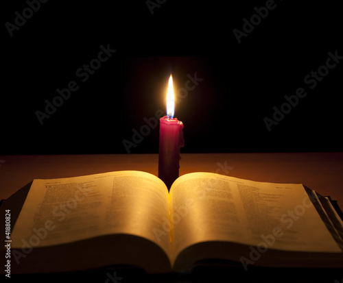 bible and candle in night