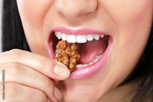 Obraz na plátne Female mouth with nut