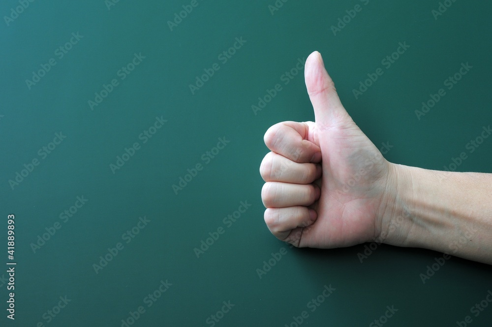 Thumb up on a blackboard background