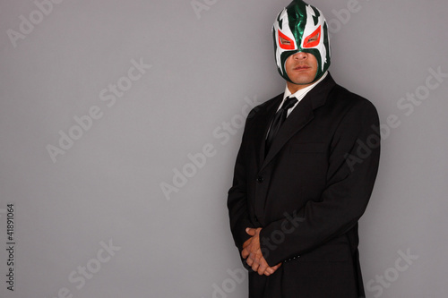 Man wearing a suit and luchador mask. photo
