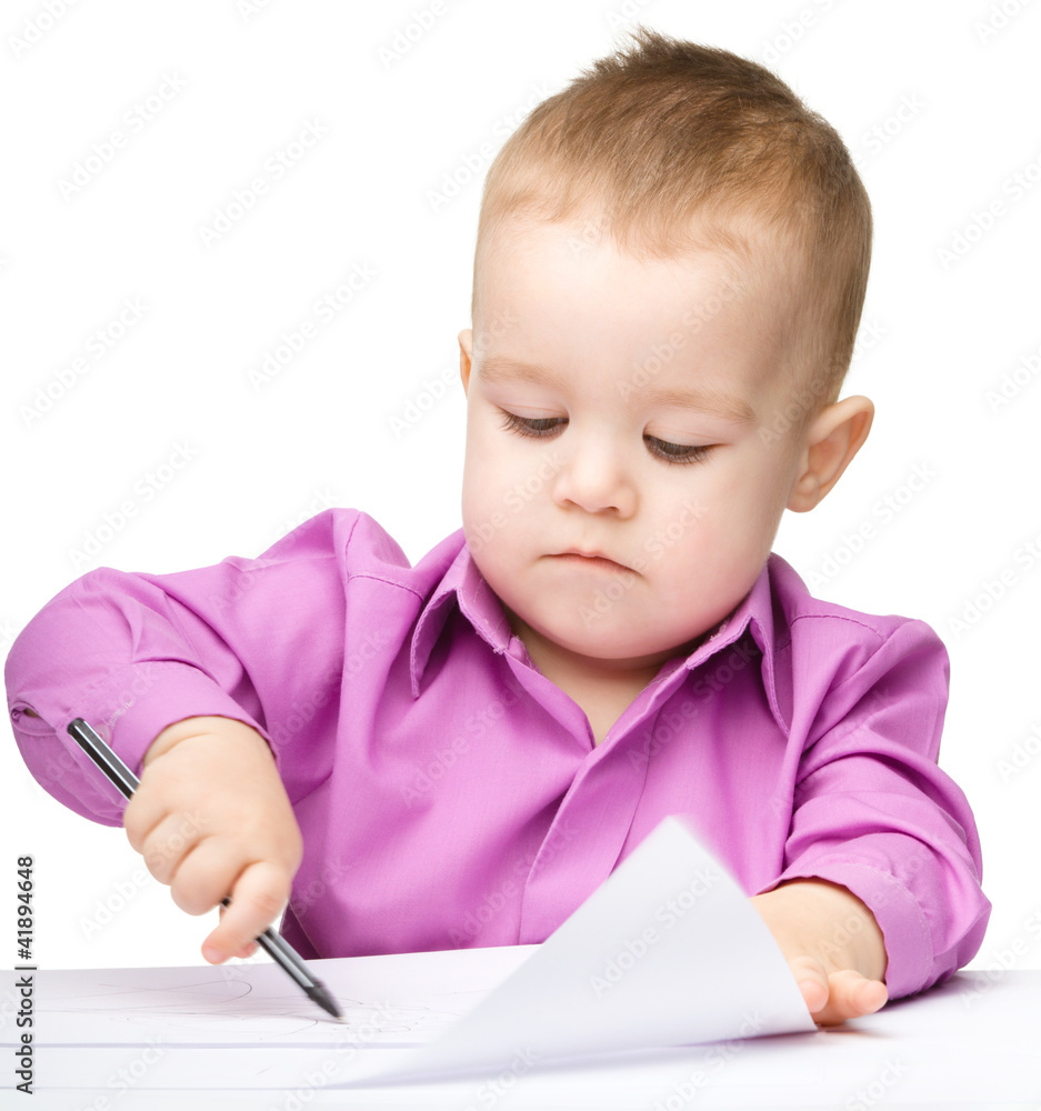 Cute little boy is drawing with pen Cute little boy is drawing with pen