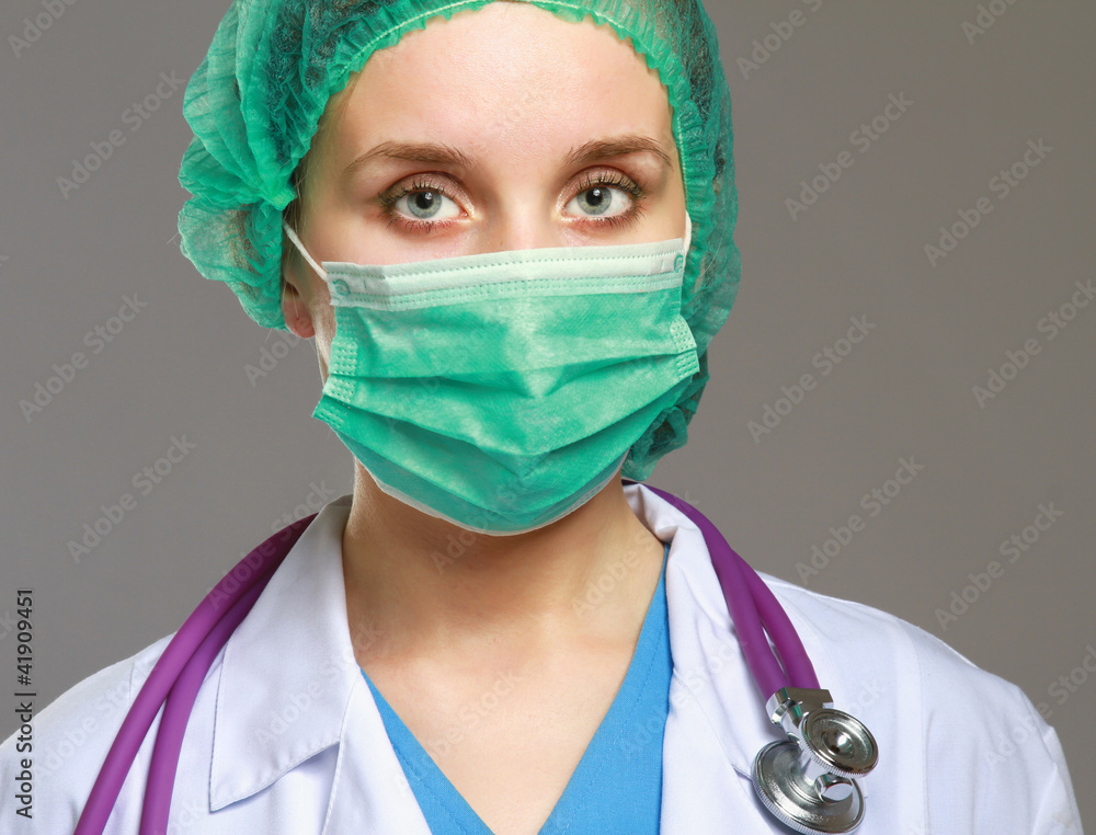 A female doctor in uniform, close-up, isolated on grey A female doctor in uniform, close-up, isolated on grey