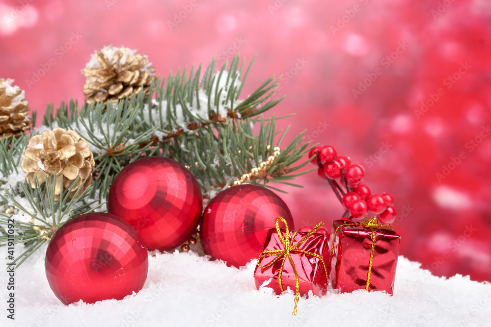 Christmas ball and green tree in the snow on red