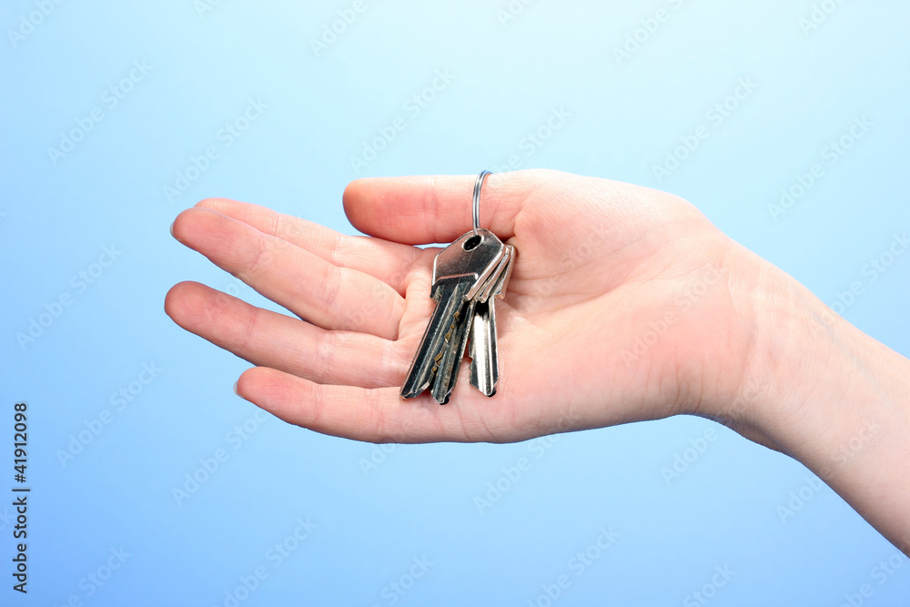 Keys in hand on blue background