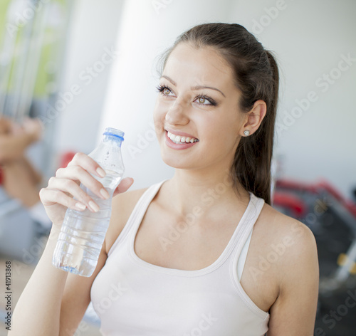 Girl drinking water in the gym