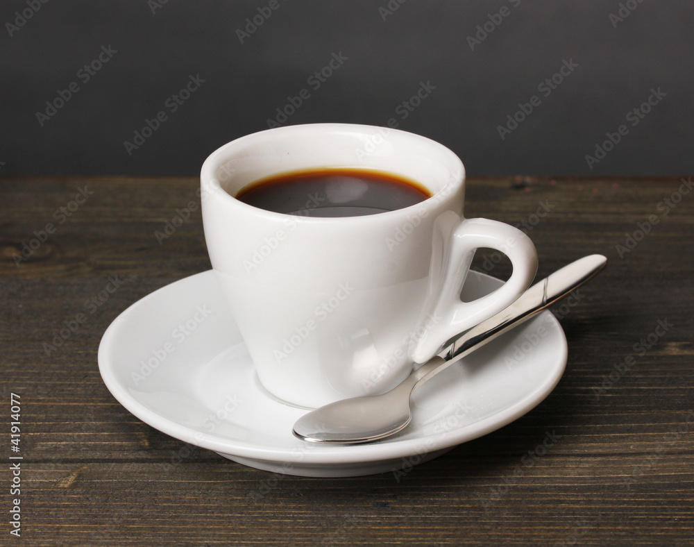 Coffee cup on wooden table on grey background