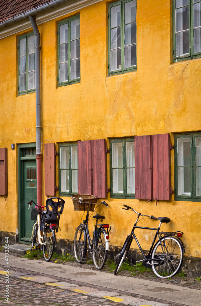 Bicycles standing next the traditional yellow building
