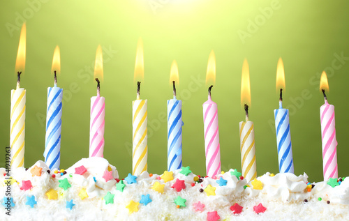 beautiful birthday candles on green background