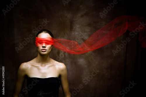 Fotografie Beauty brunette with red ribbon on eyes
