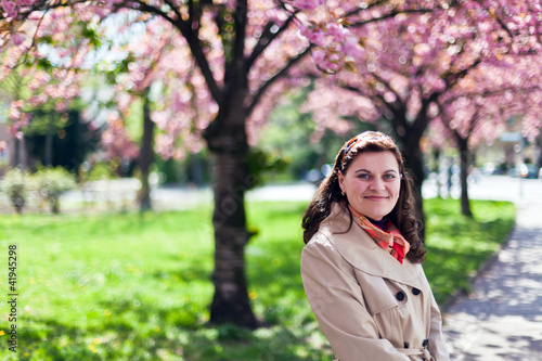 Beautiful woman in spring garden with sakura on background