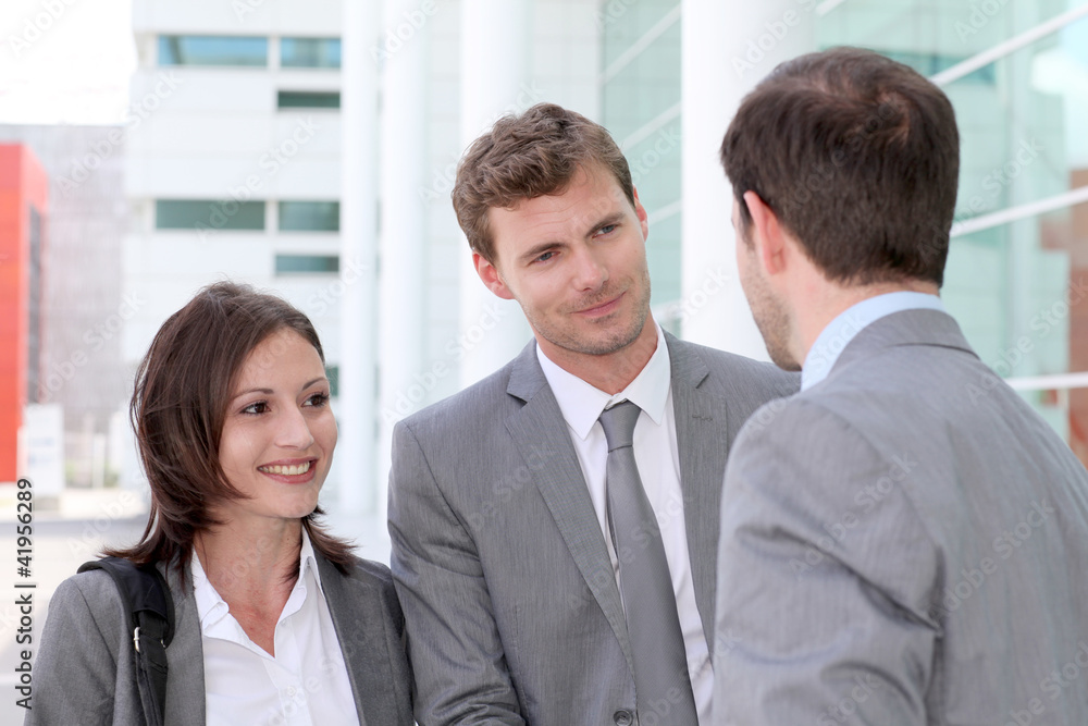Business people meeting outside office building Business people meeting outside office building