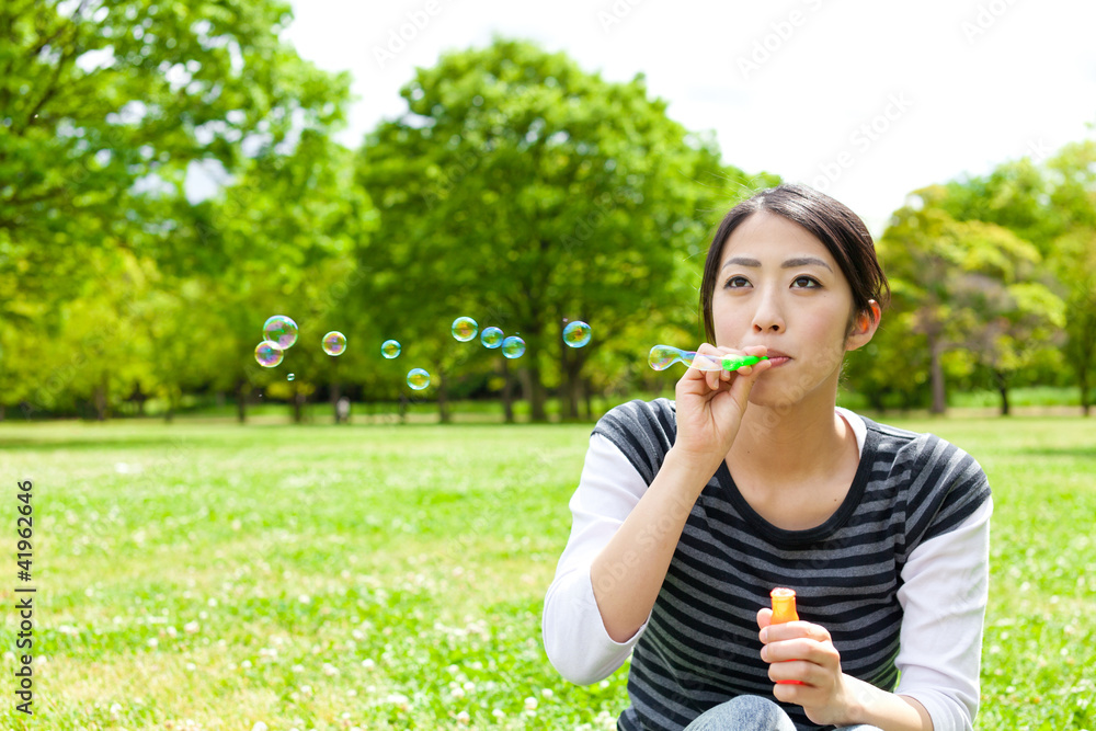 young asian woman with soap bubble in the park young asian woman with soap bubble in the park