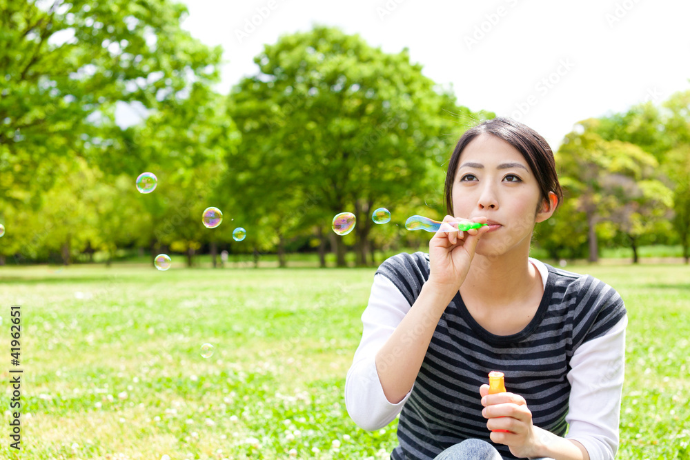 young asian woman with soap bubble in the park young asian woman with soap bubble in the park