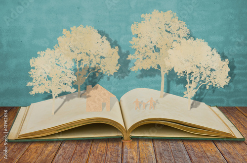 Paper cut of family symbol on old book  ( House,Tree,Mom,Dad,Chi
