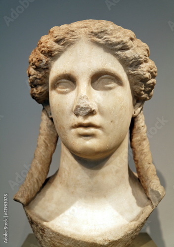 Visage de femme au nez cassé. Sculpture de pierre.