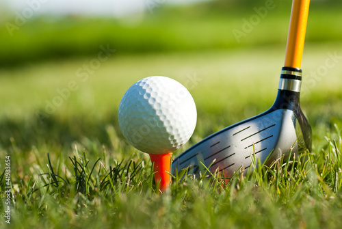 golf ball on tee and club behind