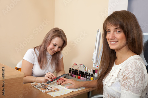 manicurist working with female nails