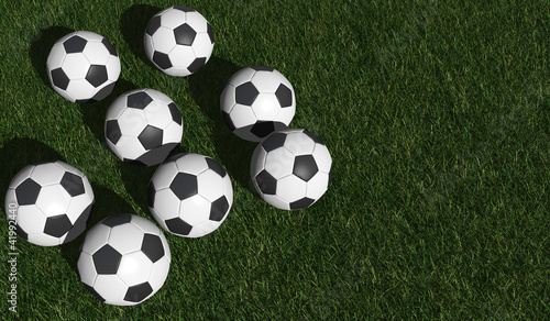 Soccer balls on a green grass