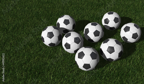 Soccer balls on a green lawn