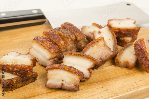 Siu Yuk - Chinese roast pork belly on a board with a cleaver