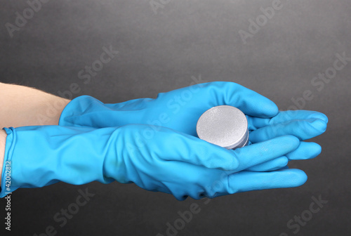 Uranium in hands on grey background