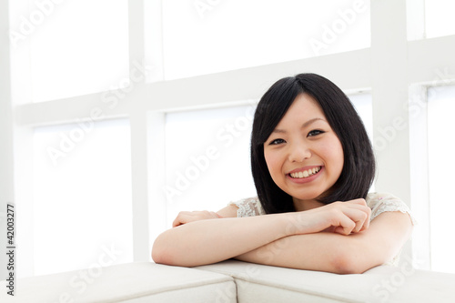 Beautiful young woman relaxing living room. Portrait of asian.