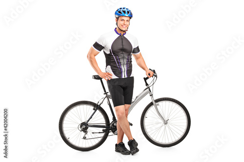 Smiling bicyclist posing next to a bicycle