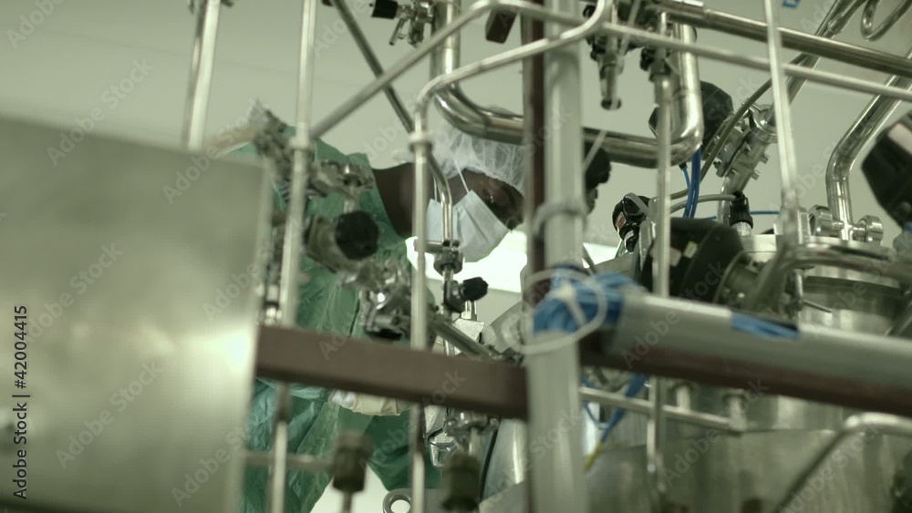 Man checking machinery in pharmaceutical laboratory Man checking machinery in pharmaceutical laboratory