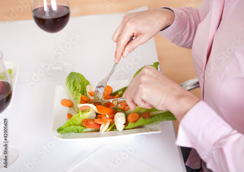 Woman eating salad at home
