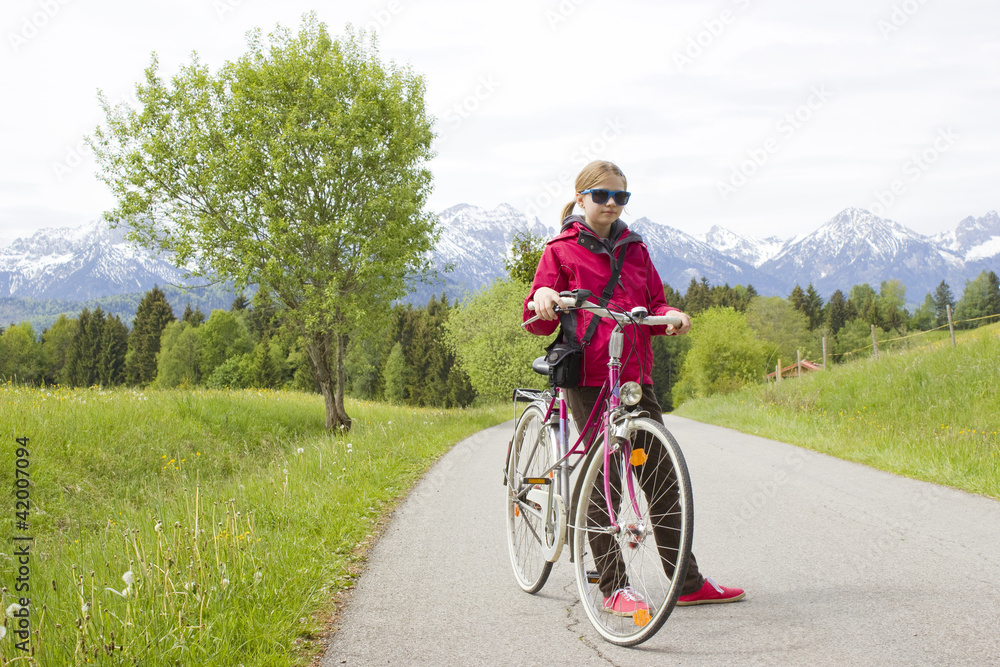 young girl with the bike in the mountains
