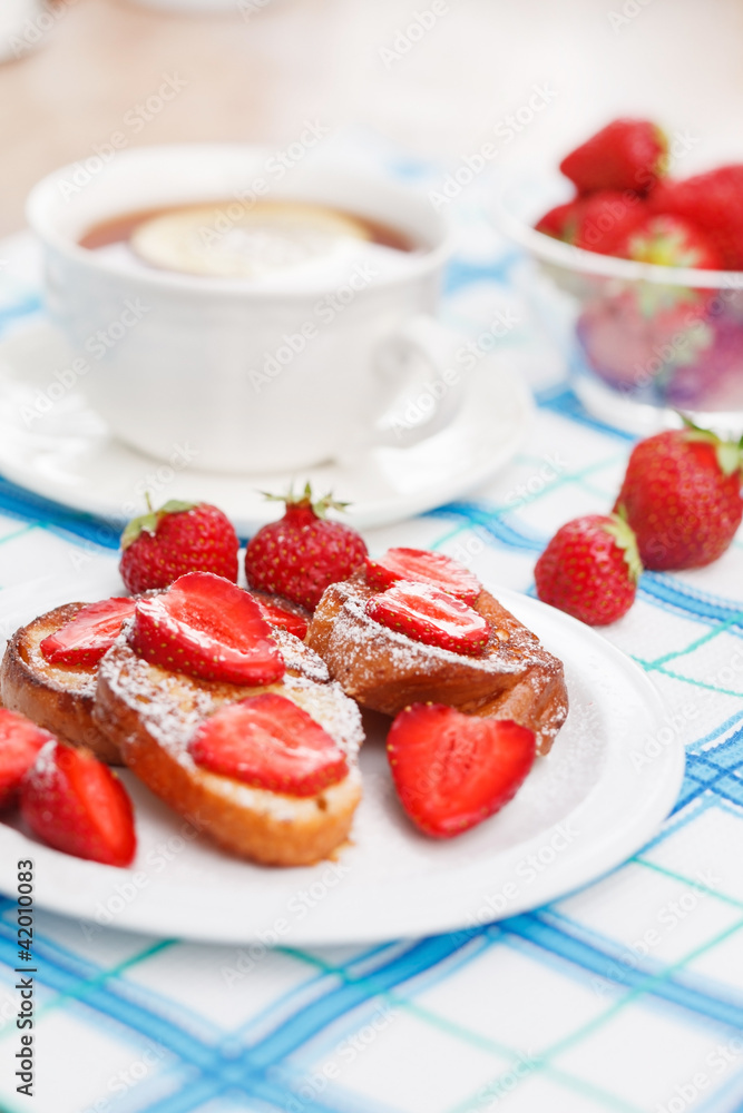 French toasts with powdered sugar and a strawberry French toasts with powdered sugar and a strawberry