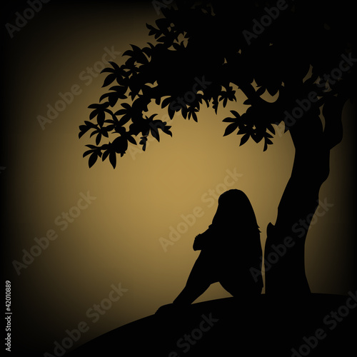 The outline of a girl sitting near a tree