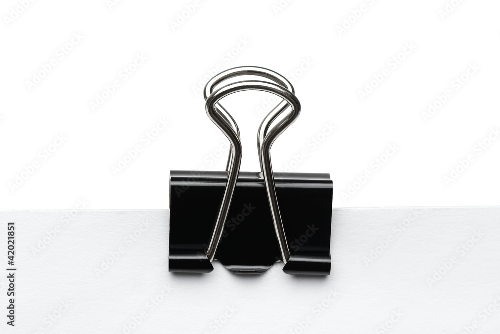 Black paper clip at the piece of paper Black paper clip at the piece of paper