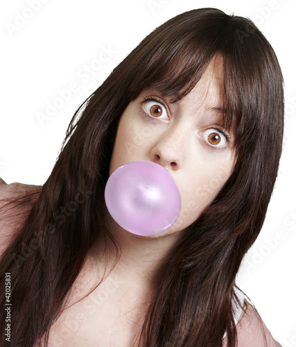 young girl with a pink bubble of chewing gum against a white bac
