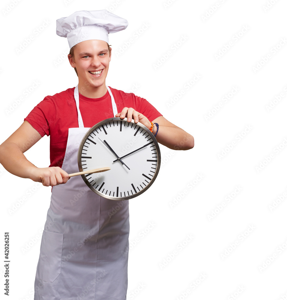 portrait of young cook man pointing a clock over white backgroun portrait of young cook man pointing a clock over white backgroun