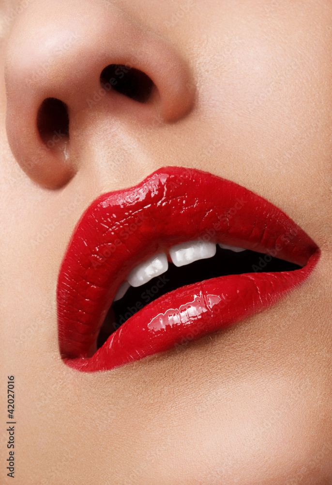 Fototapeta premium Close-up shot of woman lips with glossy red lipstick