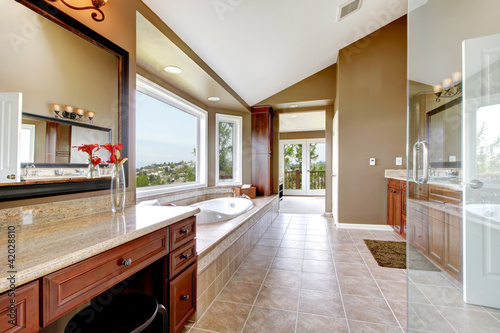 Large modern luxury new master bathroom in brown.