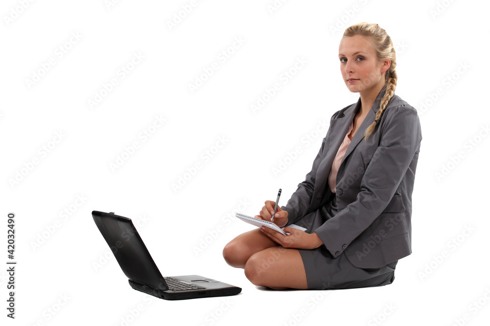 Businesswoman taking notes in front of her laptop Businesswoman taking notes in front of her laptop