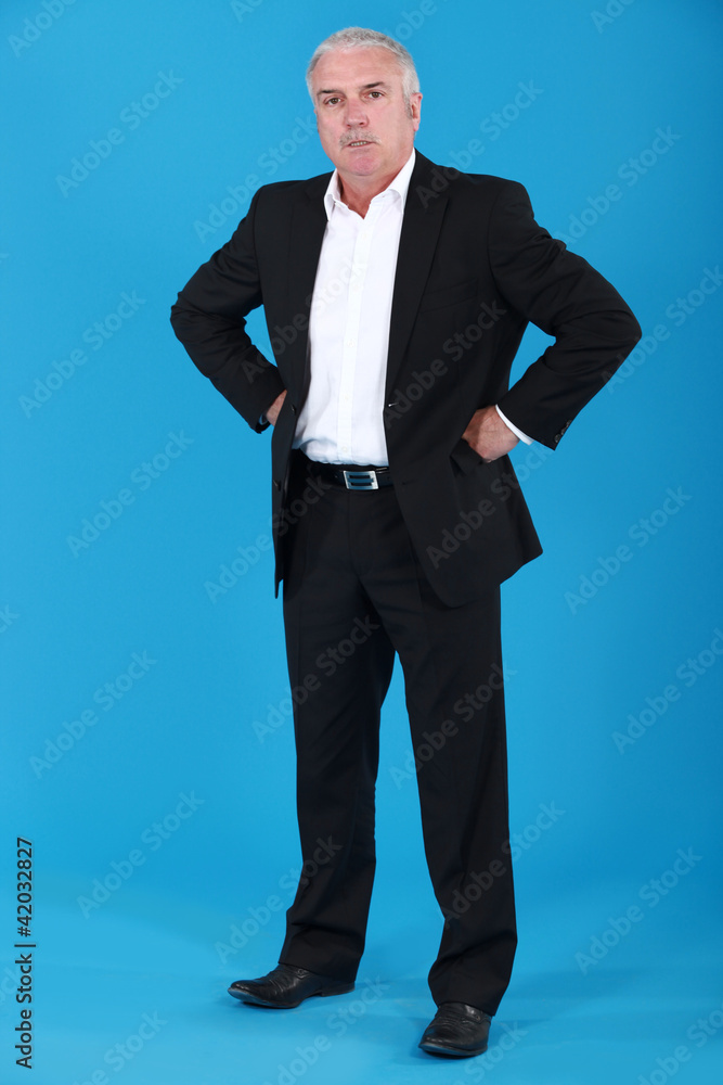 anxious businessman standing on blue background anxious businessman standing on blue background