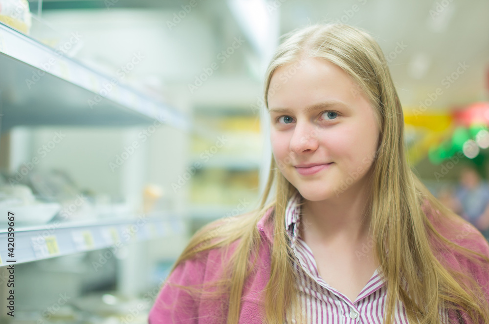 Young woman near shelves in supermarket Young woman near shelves in supermarket