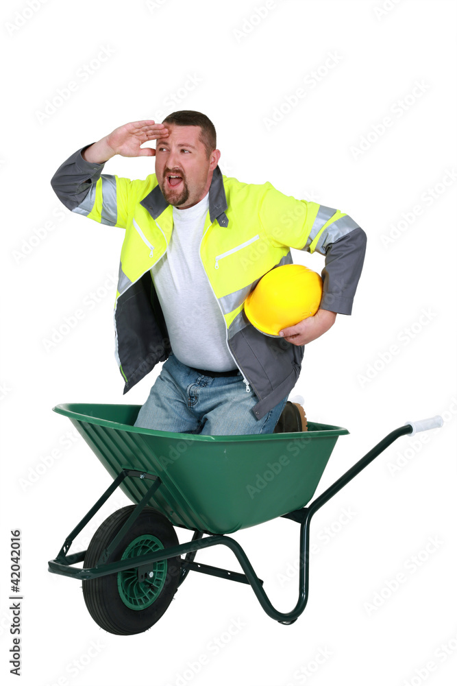 Construction worker in a wheelbarrow Construction worker in a wheelbarrow