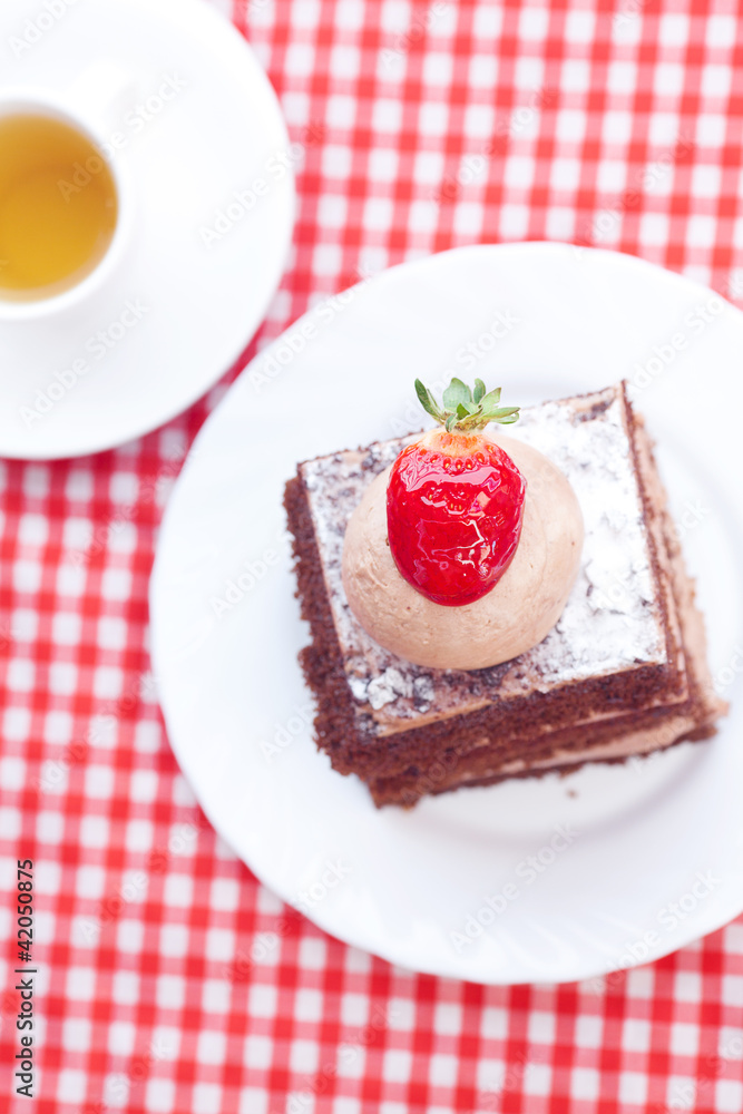 beautiful cake with strawberry and tea on plaid fabric beautiful cake with strawberry and tea on plaid fabric