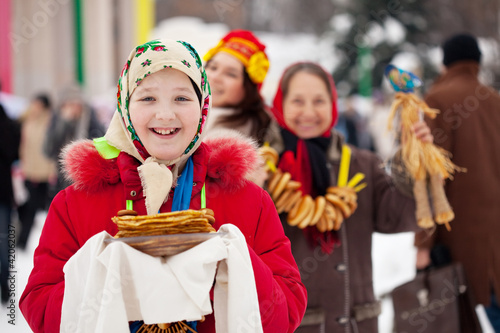 Teen girl with pancake during Shrovetide