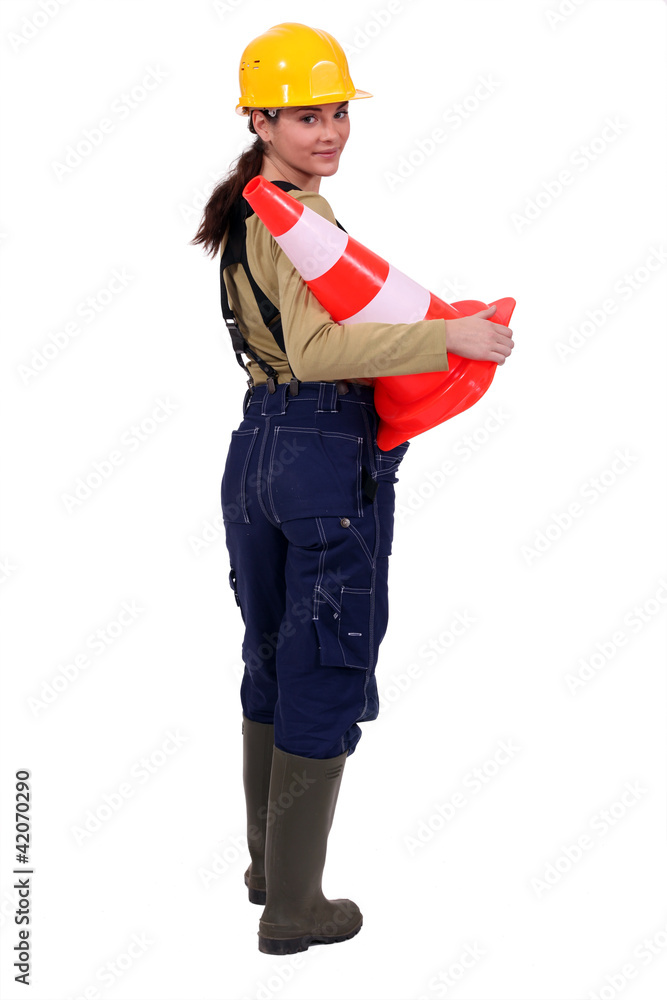 female bricklayer holding construction cone isolated on white female bricklayer holding construction cone isolated on white