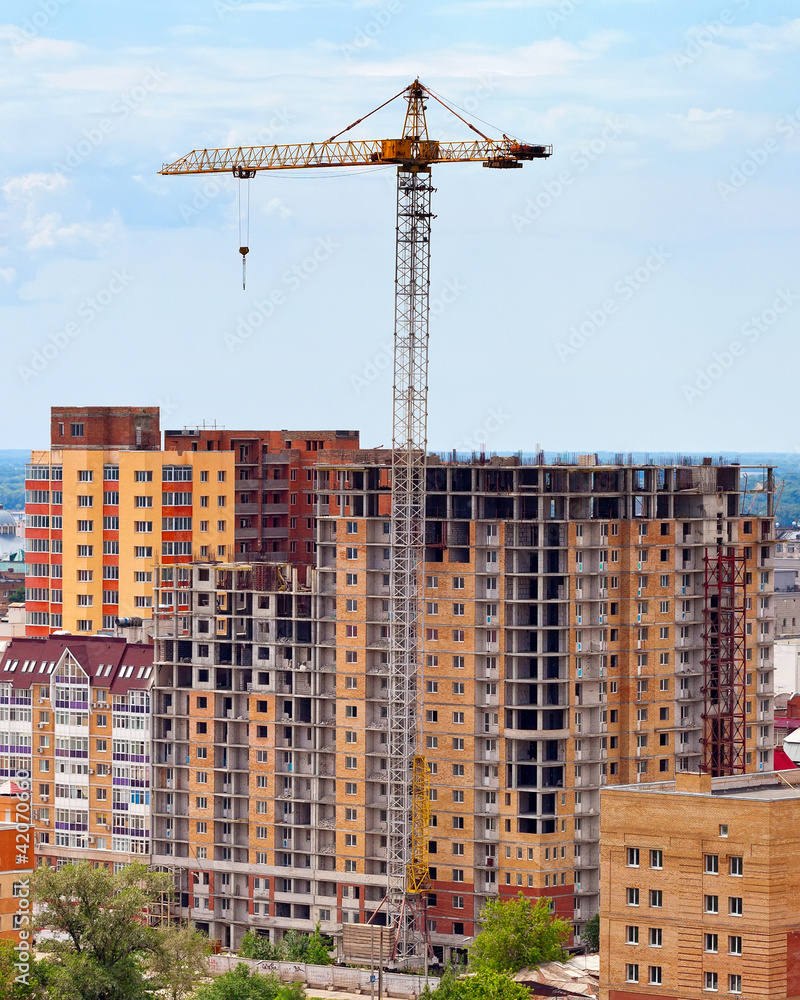 Building under construction with crane over blue sky background Building under construction with crane over blue sky background