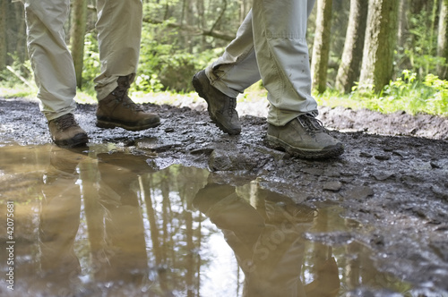 Hikers Walking Through Mud Puddle