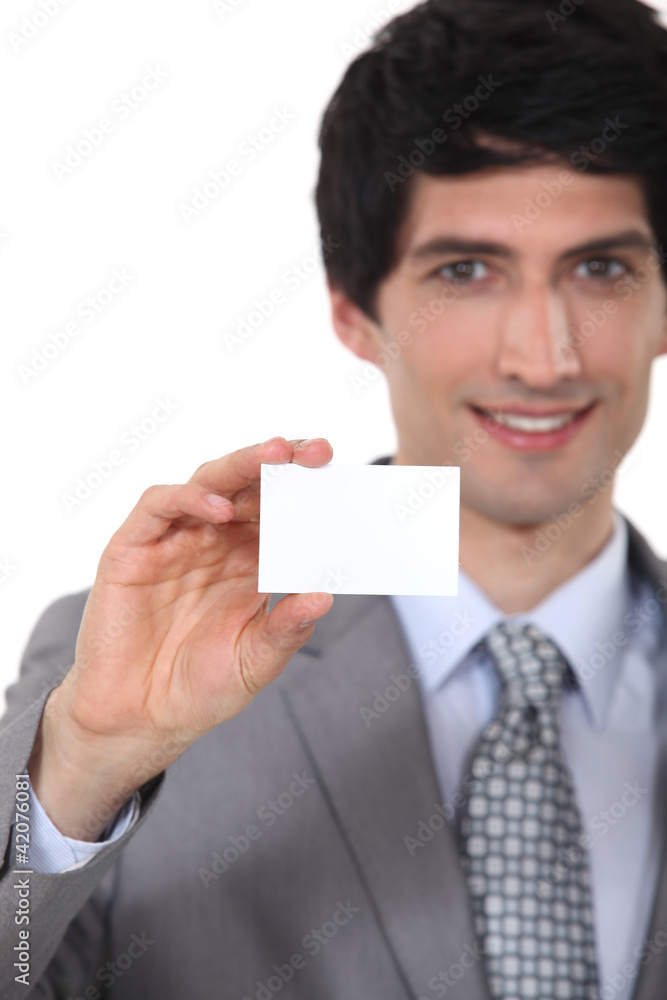 Businessman holding up a blank business card Businessman holding up a blank business card