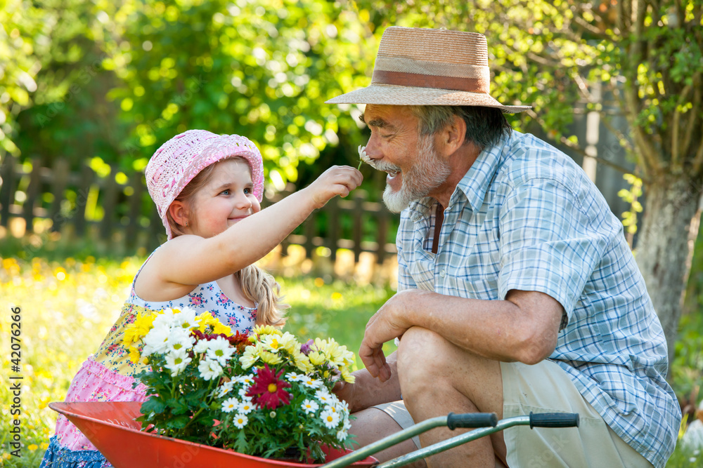 Happy grandfather with his granddaughter in the garden Happy grandfather with his granddaughter in the garden